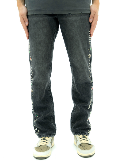 black jeans with colorful embellishments on a white background